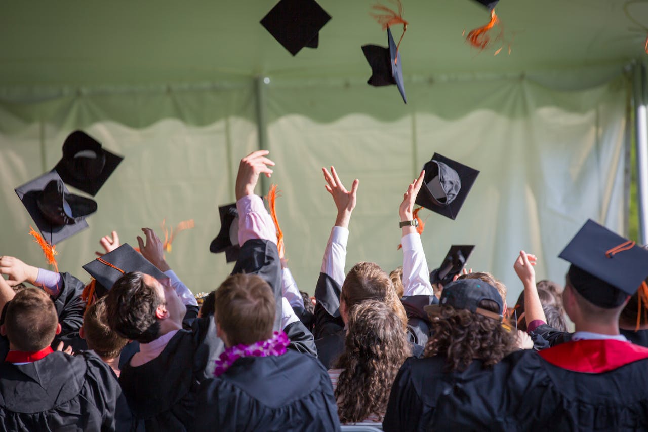 services-img Group of graduates celebrating by tossing caps into the air during a graduation ceremony.
